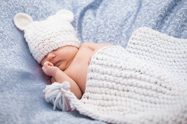 Niedliches neugeborenes Mädchen mit Strickmütze auf dem weißen Hinterhof — Stockfoto