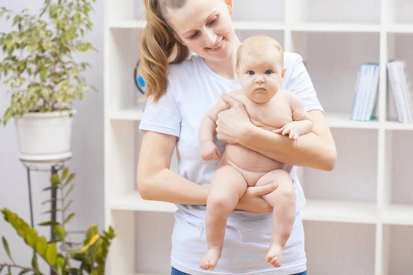 Jong gelukkig vrouw houden van een pasgeboren baby in haar armen — Stockfoto