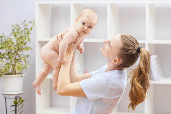 Giovane donna felice che tiene in braccio un neonato — Foto Stock