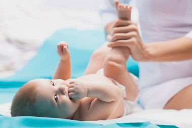 Doktor kadın jimnastik yapıyor. Yeni doğmuş şirin bebek..