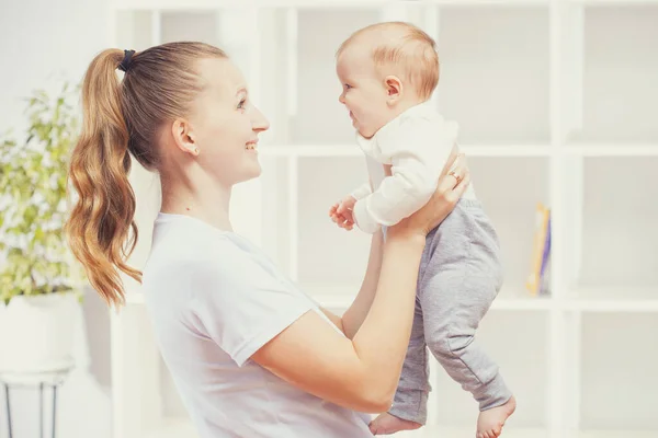 Giovane donna felice che tiene in braccio un neonato — Foto Stock