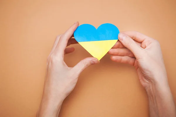 Heart with print the national flag of ukraine in female hands. — Stock Photo, Image