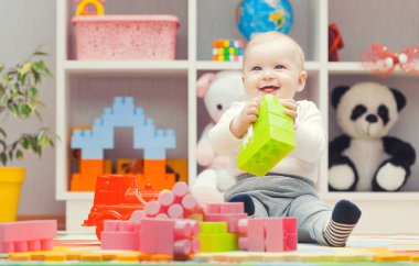 bebek evde ya da anaokulunda renkli yapı taşlarıyla oynuyor.