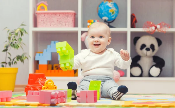 Baby playing with colourful building blocks at home or kindergarten — ストック写真