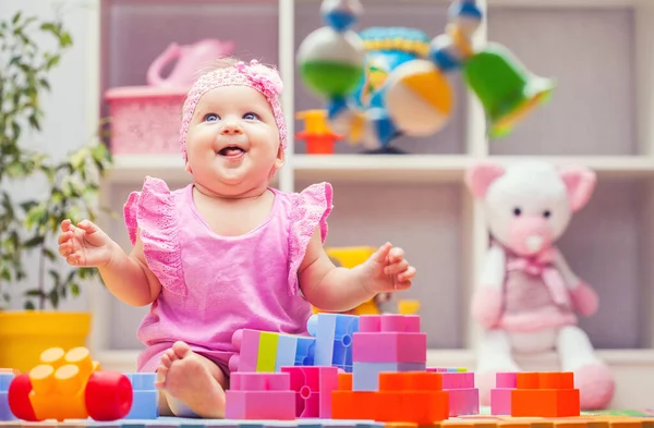 Baby girl playing with colourful building blocks at home or kindergarten — Stok fotoğraf