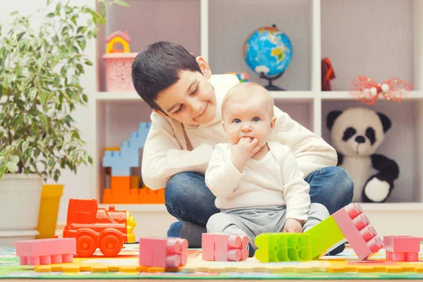 Kids playing with colourful building blocks at home or kindergarten — Stockfoto