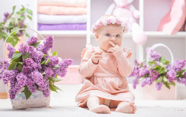 Bebé con flores de color lila en casa o jardín de infantes —  Fotos de Stock