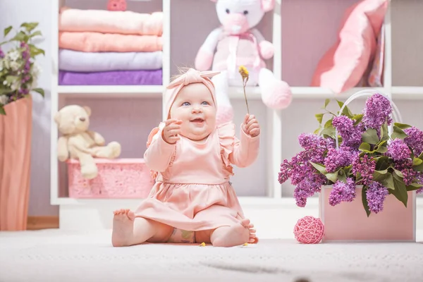 在家里或幼儿园里穿着粉红连翘花衣服的快乐婴儿 — 图库照片