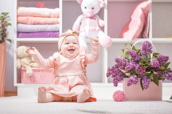 在家里或幼儿园里穿着粉红连翘花衣服的快乐婴儿 — 图库照片