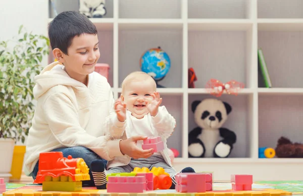 Happy Older Brother Plays Sister Colourful Building Blocks Home Kindergarten — Fotografia de Stock