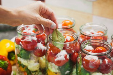 The process of preserving cucumbers and tomatoes for the winter. selective focus