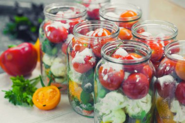 The process of preserving cucumbers and tomatoes for the winter. selective focus