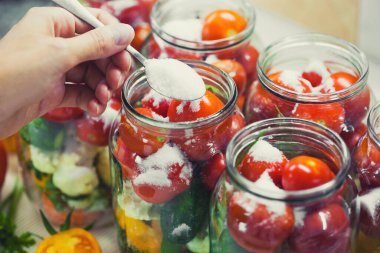The process of preserving cucumbers and tomatoes for the winter. selective focus