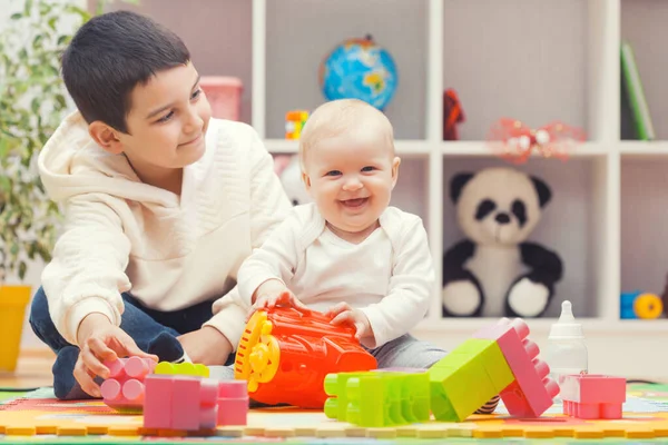 Happy Older Brother Plays Sister Colourful Building Blocks Home Kindergarten — Stockfoto