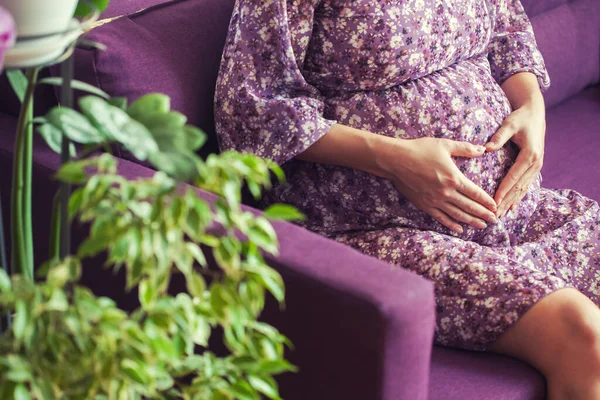 妊娠中の女性がソファに座ってる 新生児を待ってる 期待の概念 幸せな笑顔の妊婦の終わり — ストック写真