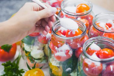 The process of preserving cucumbers and tomatoes for the winter. selective focus