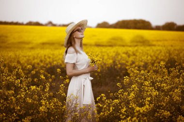 Arka planda gün doğumuyla tecavüz eden genç bir kadın.