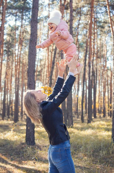 funny family games in the autumn forest, mother throws the child up