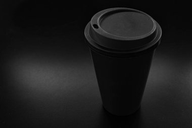 Karanlık ve dramatik bir ortamda tek kullanımlık plastik bardak.