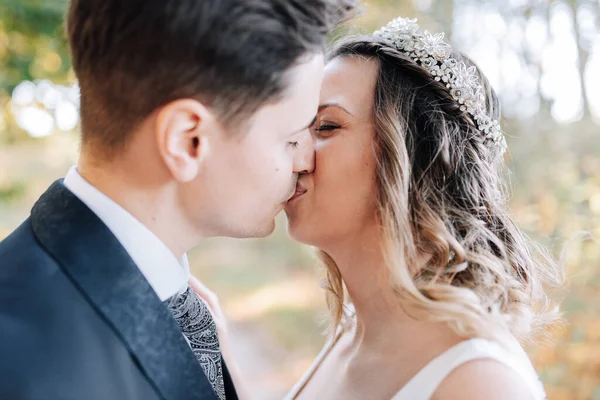 Portrait of a just married couple kissing in the woods