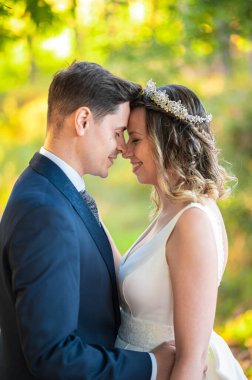 Yeni evli bir çiftin portresi alınlarına dokunuyor.