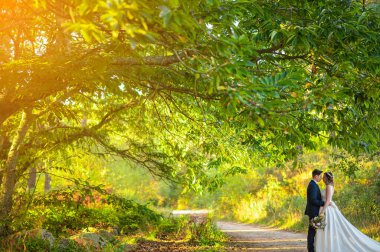 Yeşil bir ormanda birbirlerine bakan evli bir çift.