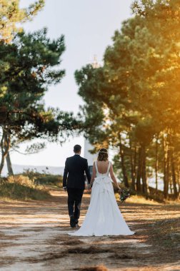 Günbatımında ormanda yürüyen evli bir çift.