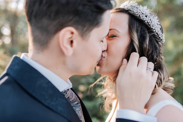 Portrait of a just married couple kissing on a forest