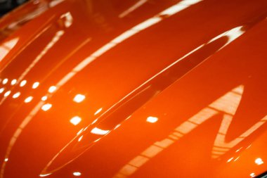 Metalik kıvrımlı parlak turuncu dokuda yansımalar var.