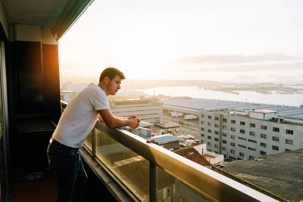 Muž Uvažující Průmyslovém Městě Balkónu Při Západu Slunce Mořem Oblohou — Stock fotografie