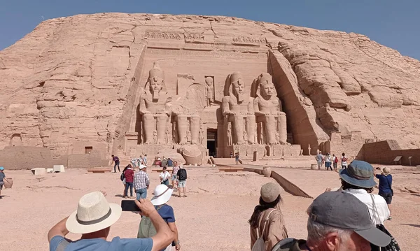 Group of tourists visiting an ancient tomb in Egypt, now a tourist attraction