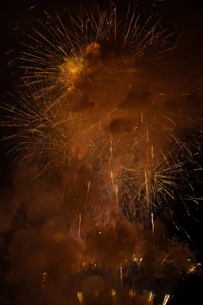 Fireworks exploding behind the smoke against black background