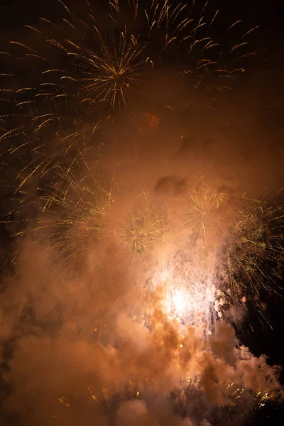 Fireworks exploding behind the smoke against black background