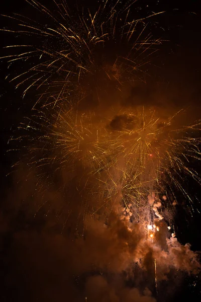 Fireworks exploding behind the smoke against black background