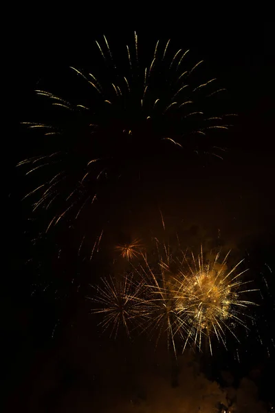 Fireworks exploding behind the smoke against black background