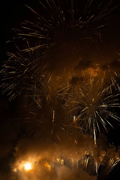 Fireworks exploding behind the smoke against black background