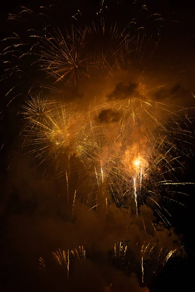 Fireworks exploding behind the smoke against black background