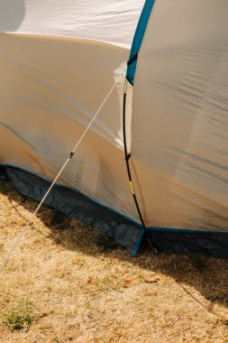 Detail of the guy lines on a camping tent planted on soil