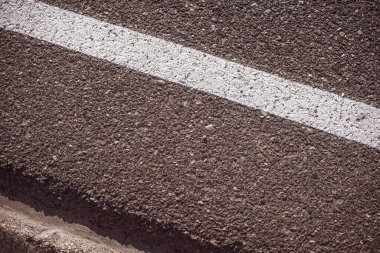 Yol kenarında beyaz çizgili bir yakın plan.