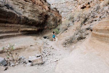 Gran Canaria 'da kurumuş bir kanyonda yürüyen bir kadın.