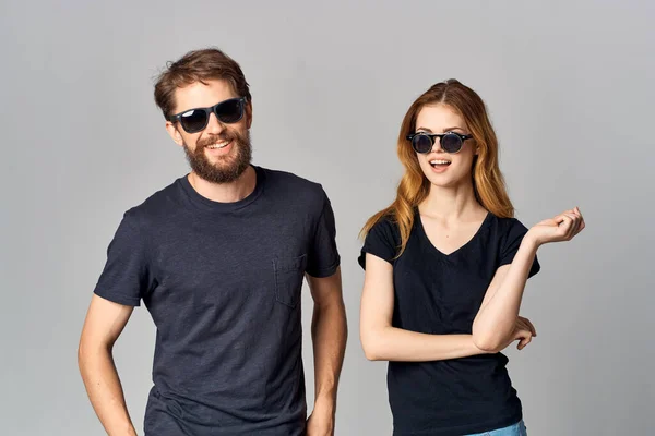 fashionable man and woman in black t-shirt sunglasses posing isolated background