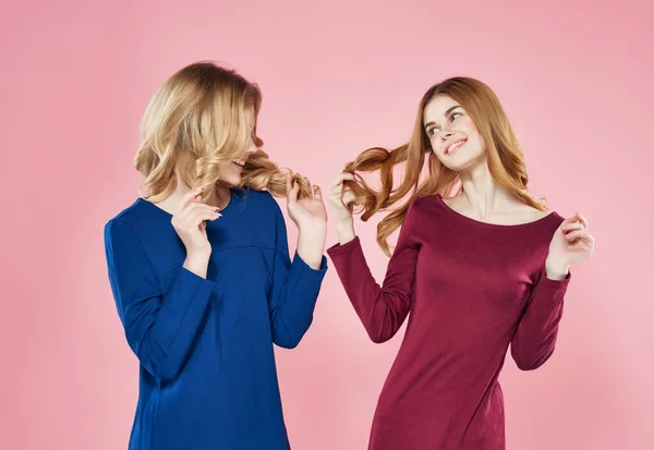 Två flickvänner i klänningar mode poserar studio — Stockfoto
