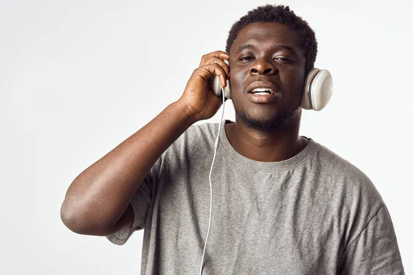 Afrika görünümlü neşeli bir adam kulaklıkla müzik dinliyor. — Stok fotoğraf