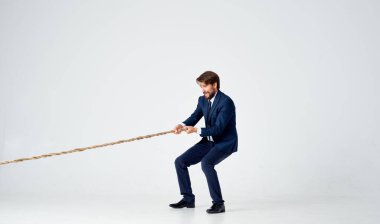 Takım elbiseli iş adamı halat çekiyor Stüdyo ekibi çalışıyor