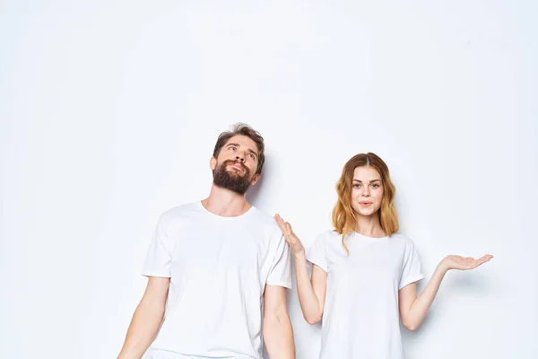 Veselý mladý pár v bílém trička a džíny studio pózovat světlo pozadí — Stock fotografie