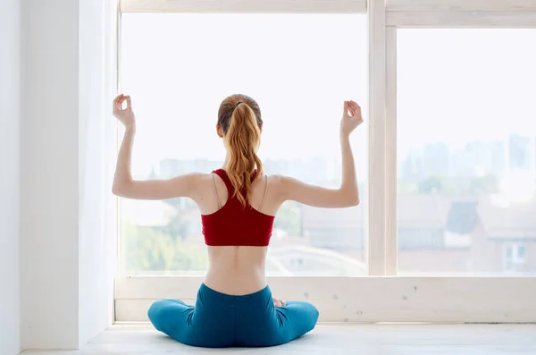 Kobieta medytująca w pobliżu okna ćwiczenia jogi — Zdjęcie stockowe