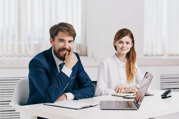 man and woman managers sitting at the table in front of laptop team technology