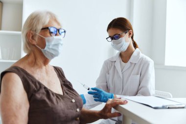 Şırıngalı bir doktor kol sağlığı hizmetine enjeksiyon yapıyor.