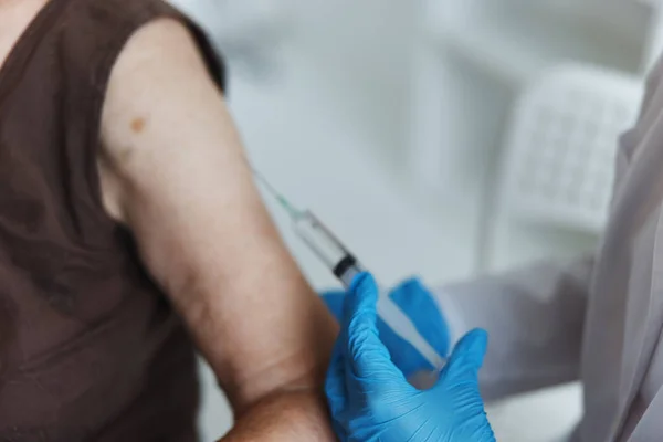 Läkare gör en injektion i armens immunitetsskydd covid pass närbild — Stockfoto