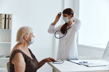 Doktor sağlık kontrolündeki yaşlı kadın hasta.